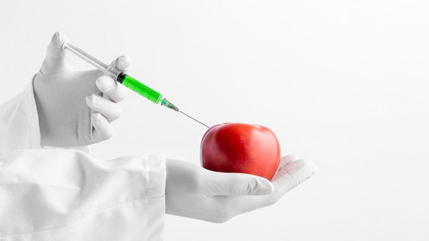 Photo person injecting apple with chemicals