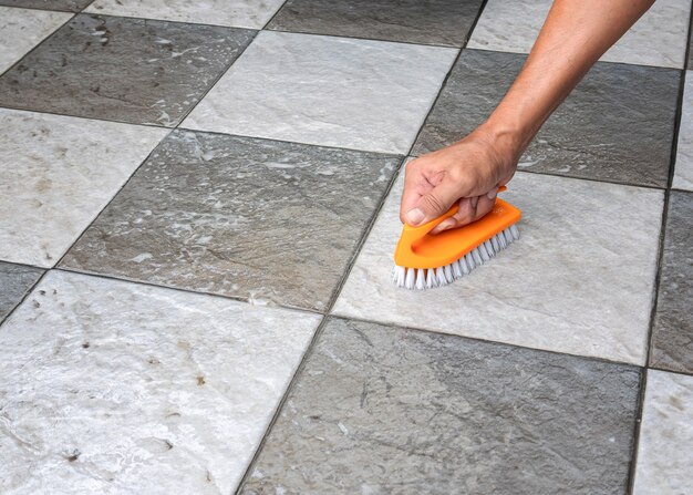 Person is cleaning the tile floor