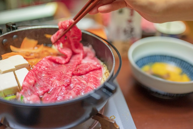 箸で牛肉料理を作っている人。