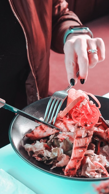 a person is cutting meat with a fork and knife