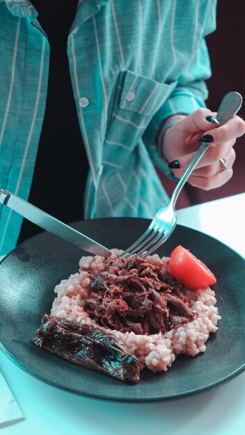 a person is eating a chocolate cake with a fork and a spoon