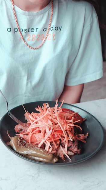 Photo a person is eating food with a fork and knife