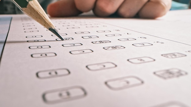 Photo a person is filling out a checklist with a pencil.