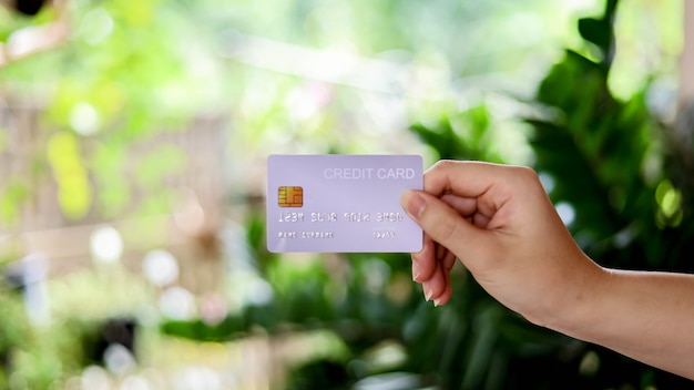 The person is holding a credit card, a credit card can be used to pay for goods and services at retail stores, restaurants, or online shopping. concept of using a credit card.