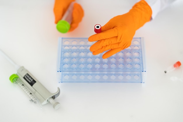 a person is holding a test tube and a marker with a marker in it