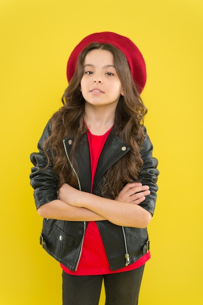 A person is a person no matter how small. Small child keeping arms crossed on yellow background. Cute small girl with long brunette hair and fashion outfit. Confident look of adorable small kid model.