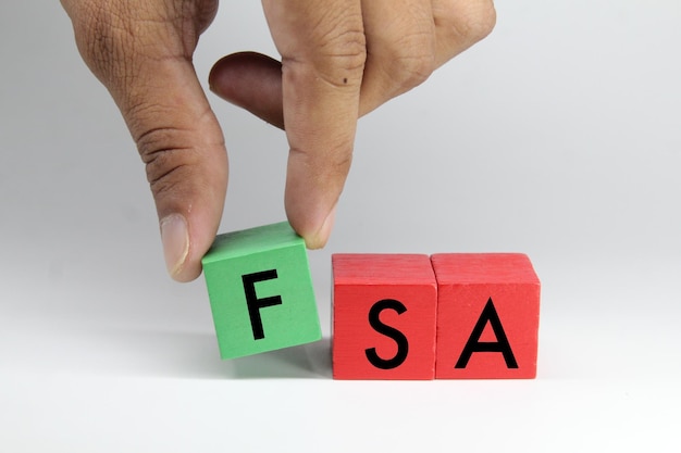 人が fsa と saa の付いたブロックを置いている