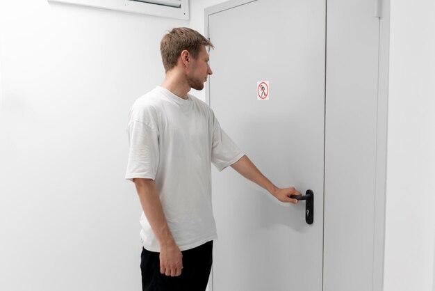 a person is seen opening a door with a clear no entry sign posted ignoring security protocol