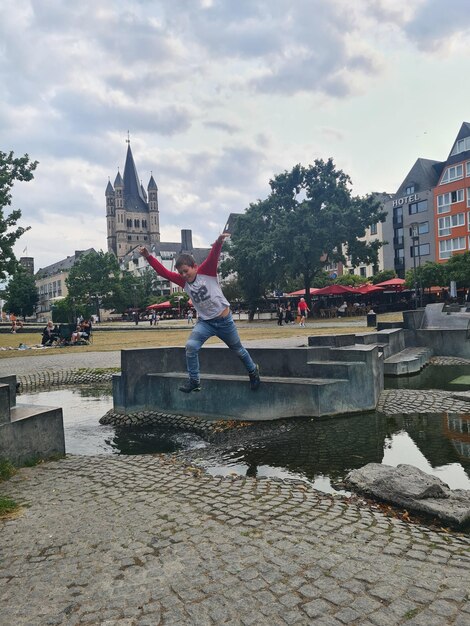 A person is standing on a bridge with a building in the background.