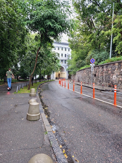 A person is walking down a street with orange cones.