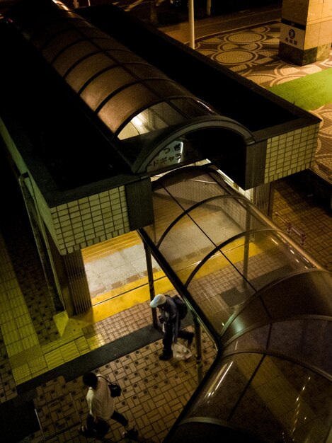 緑の芝生を背景に建物の前を人が歩いている。