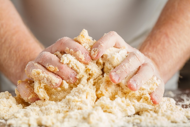 Person kneading dough on wooden table