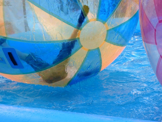 Foto persona in una grande palla gonfiabile sopra la piscina