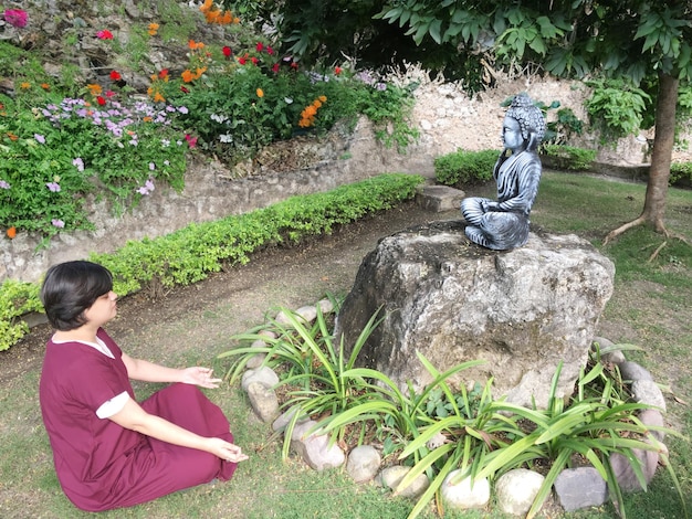 Person Meditating in front of Buddha