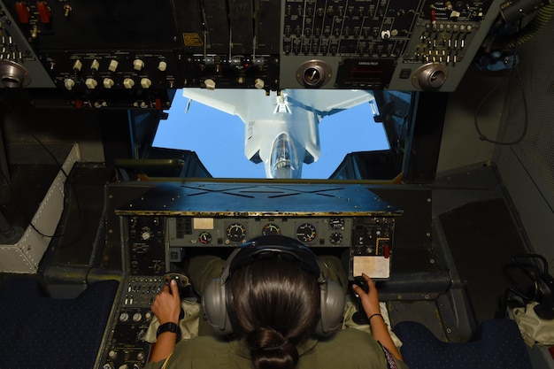 Foto una persona in uniforme militare sta guardando un jet da combattimento.