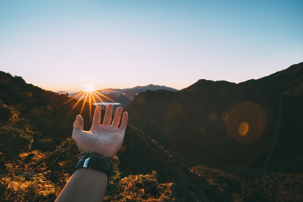 Photo person on mountain against sky during sunset