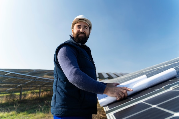 Foto persona vicino a un impianto di energia alternativa