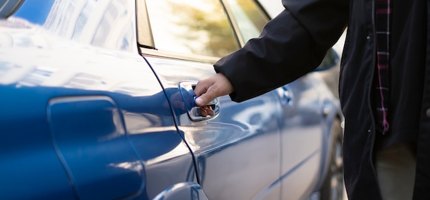 The person open blue car door and sit inside, auto journey\
start