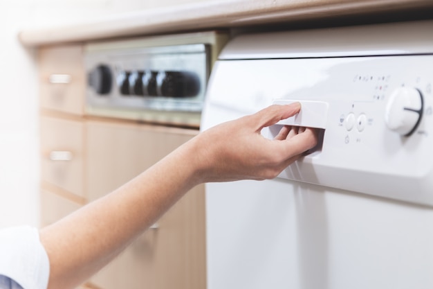 Person opening the dishwasher in the kitchen of the apartment