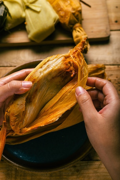 タマレを手で開ける人 タマレの典型的なメキシコ料理