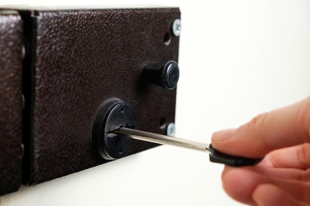 A person opens a modern durable lock with a key a closeup hand