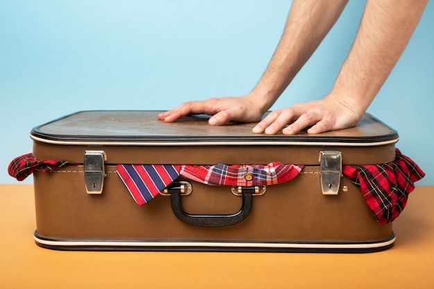 Photo person packing leather suitcase with clothes