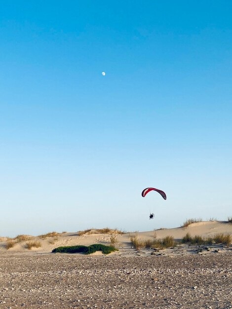 Person paragliding against clear sky