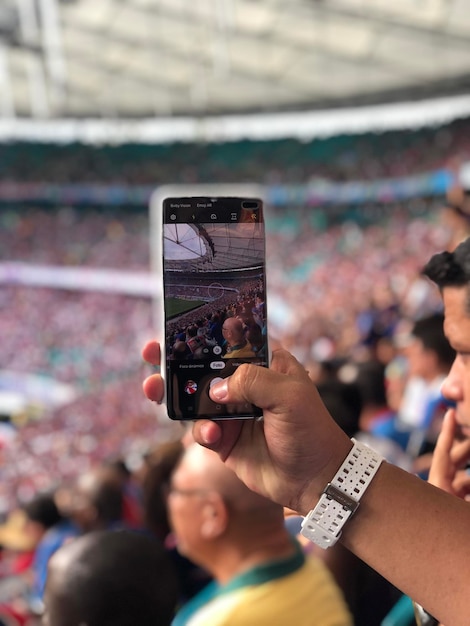 Photo person photographing with mobile phone in stadium