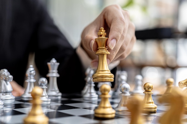 Person playing chess board game, business woman concept image holding chess pieces like business competition and risk management, planning business strategies to defeat business competitors.