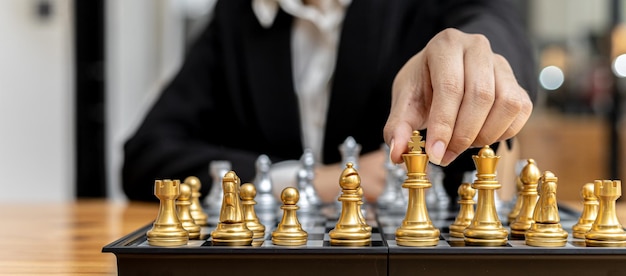 Person playing chess board game, business woman concept image holding chess pieces like business competition and risk management, planning business strategies to defeat business competitors.