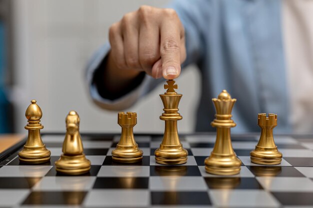 Человек, играющий в шахматную настольную игру, концептуальный образ деловой женщины, держащий шахматные фигуры, такие как бизнес-соревнование и управление рисками, планирование бизнес-стратегий для победы над бизнес-конкурентами.