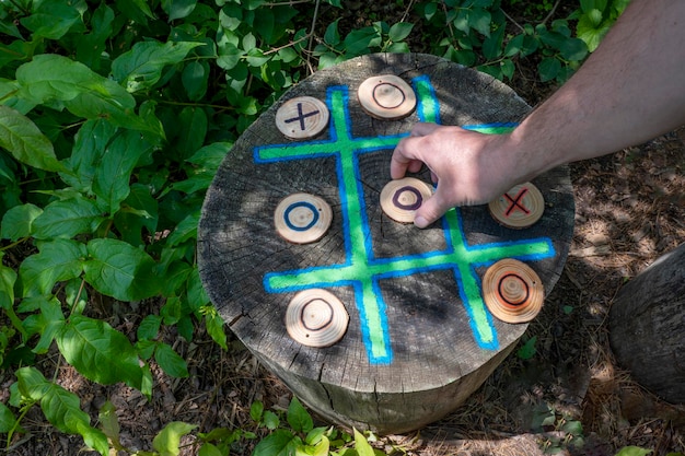 person playing tic tac toe made out of wood in park