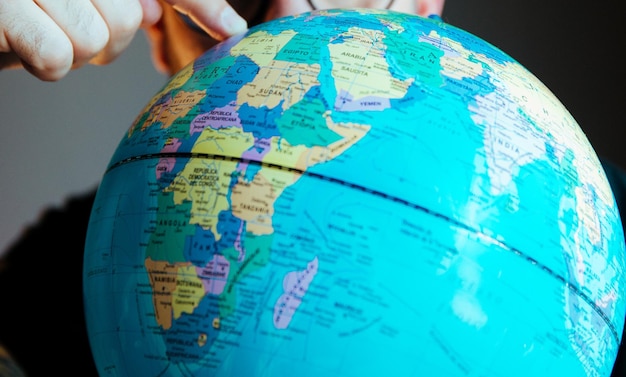 Photo person pointing travel destination on globe