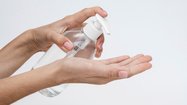 Photo person pouring liquid soap from a bottle with copy space