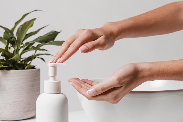 Person pouring soap in hand side view