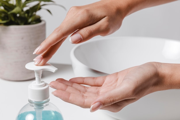 Photo person pouring soap in hand next to the sink