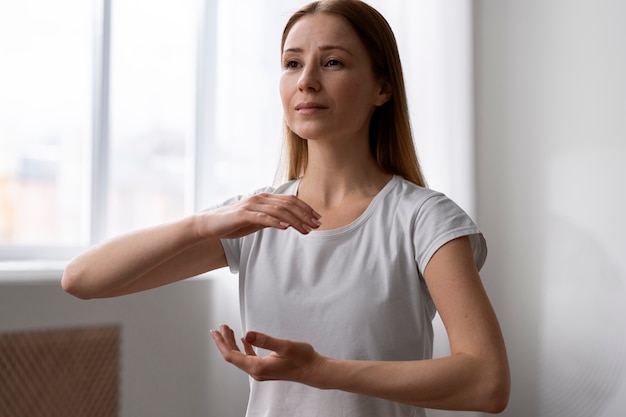 Foto persona che pratica il tai chi al chiuso