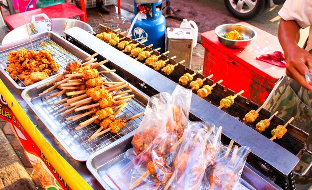 Person preparing food on barbecue grill at market