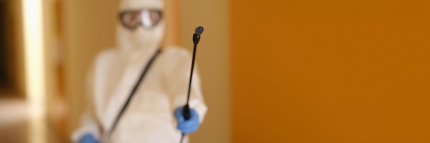 Photo person in protective suit holding disinfection equipment in hand