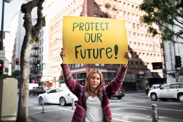 Photo person protesting with placard in the city for world environment day