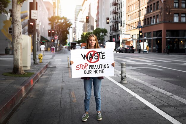 Persona che protesta con il cartello in città per la giornata mondiale dell'ambiente