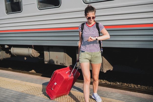 A person pulling the baggage bag on the train station