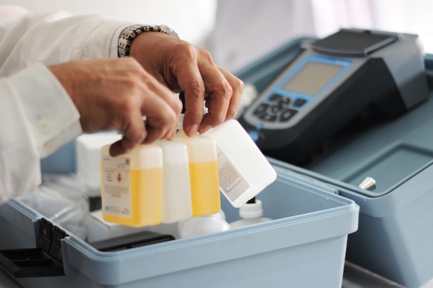 A person putting a bottle of medicine into a bin