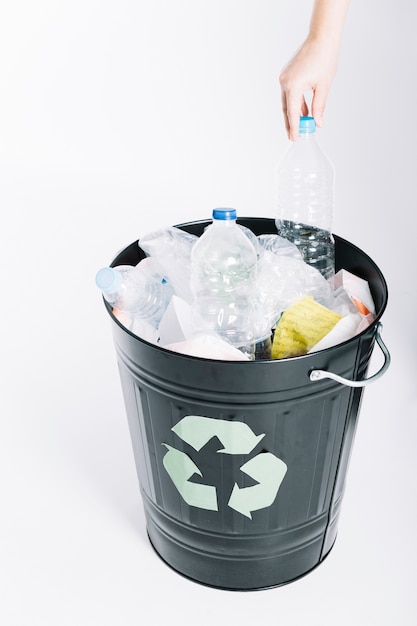 Photo a person putting garbage in the recycle bucket against white background