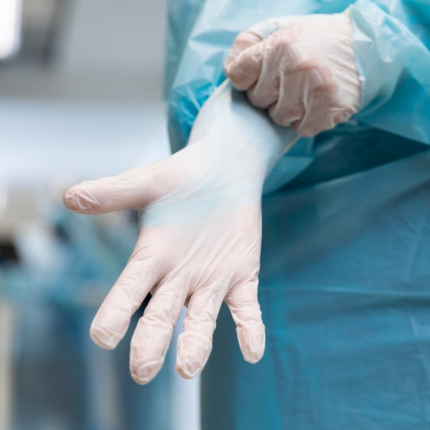 Photo person putting on surgical gloves