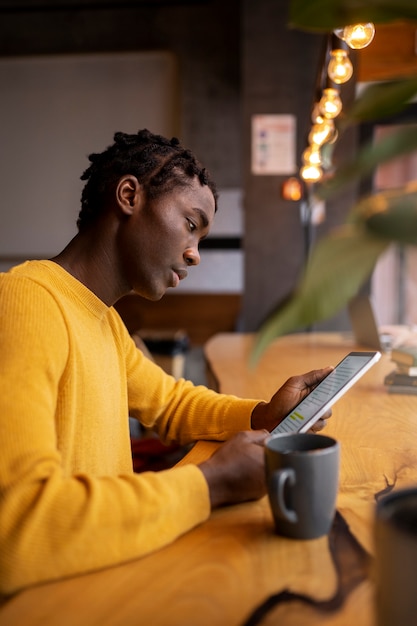 Foto persona che legge un libro in un caffè