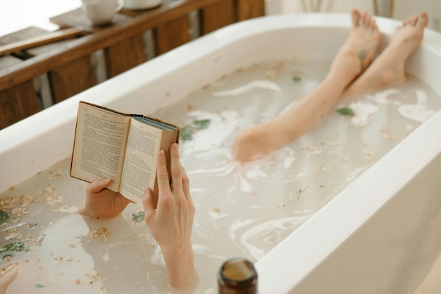 Photo a person reading a book while bathing in a bathtub photo