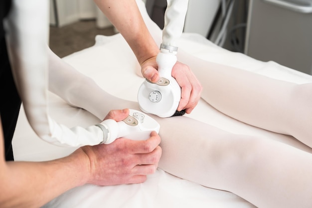 a person receives a skin treatment on their legs with specialized devices