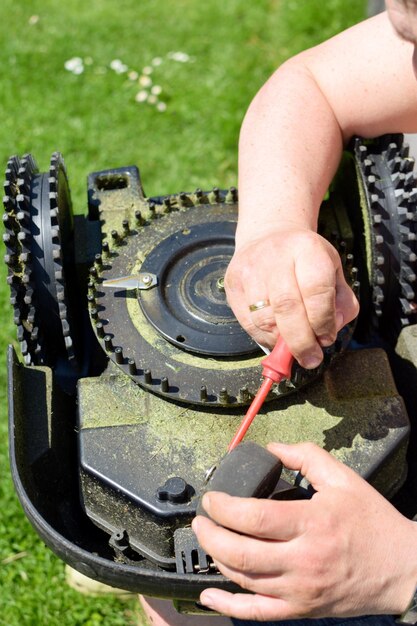 Person repairing robotic lawn mower