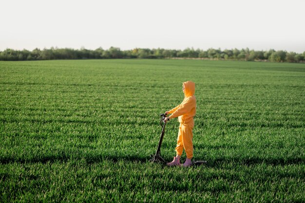 Person rides electric scooter on green field